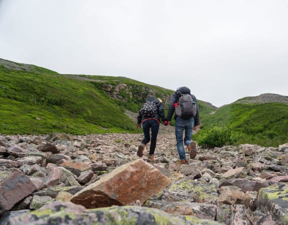 a couple walking on a rocky hillside
