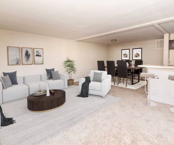 a living room with white couches and chairs and a bar with stools at Stevenson Lane Apartments, Towson MD