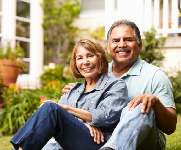 Older Couple Sitting on Lawn Together Smiling