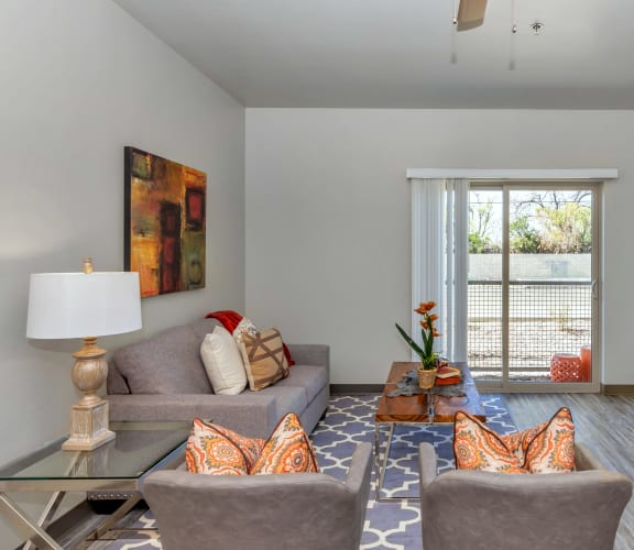 a living room with gray walls and a sliding glass door at Allora Phoenix Apartments, Phoenix, Arizona