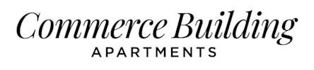 A black and white image of a sign for Commerce Building Apartments.