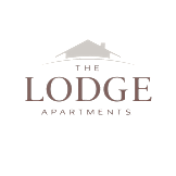 The image shows a logo with the text "The Lodge Apartments" in a glowing, three-dimensional font.