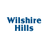 a blue logo with the words whispering hills on a white background