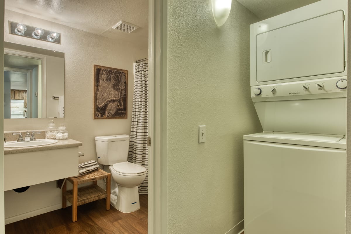 Bathroom vanity beside a stacked laundry area — view 1 at Connect on Northern Apartments.