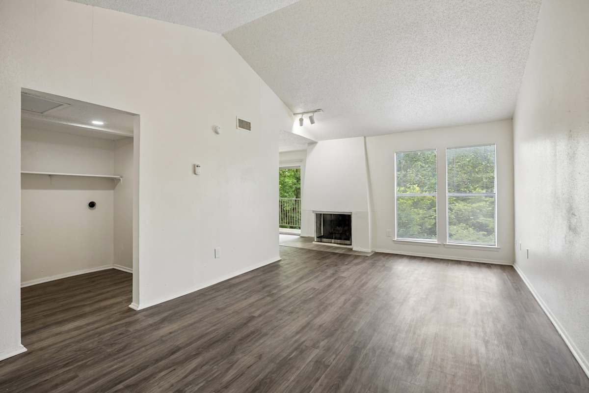 Tealwood Apartment Homes living area with wood flooring and fireplace - Dallas, TX