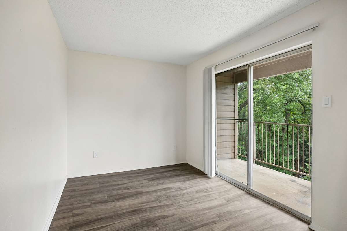 Tealwood Apartment Homes room with sliding door to balcony - Dallas, TX