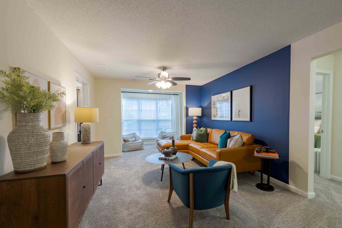 Reserve at Carrington Place apartment living room with blue accent wall - Fayetteville, NC