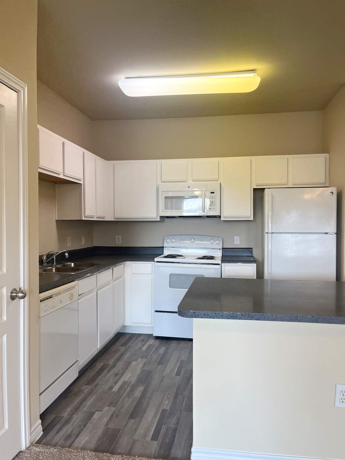 Refugio Place kitchen with white cabinets and black countertop - San Antonio, TX