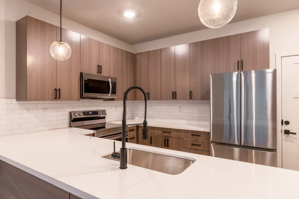 The Venue Townhomes kitchen with island and stainless appliances - Raymore, MO