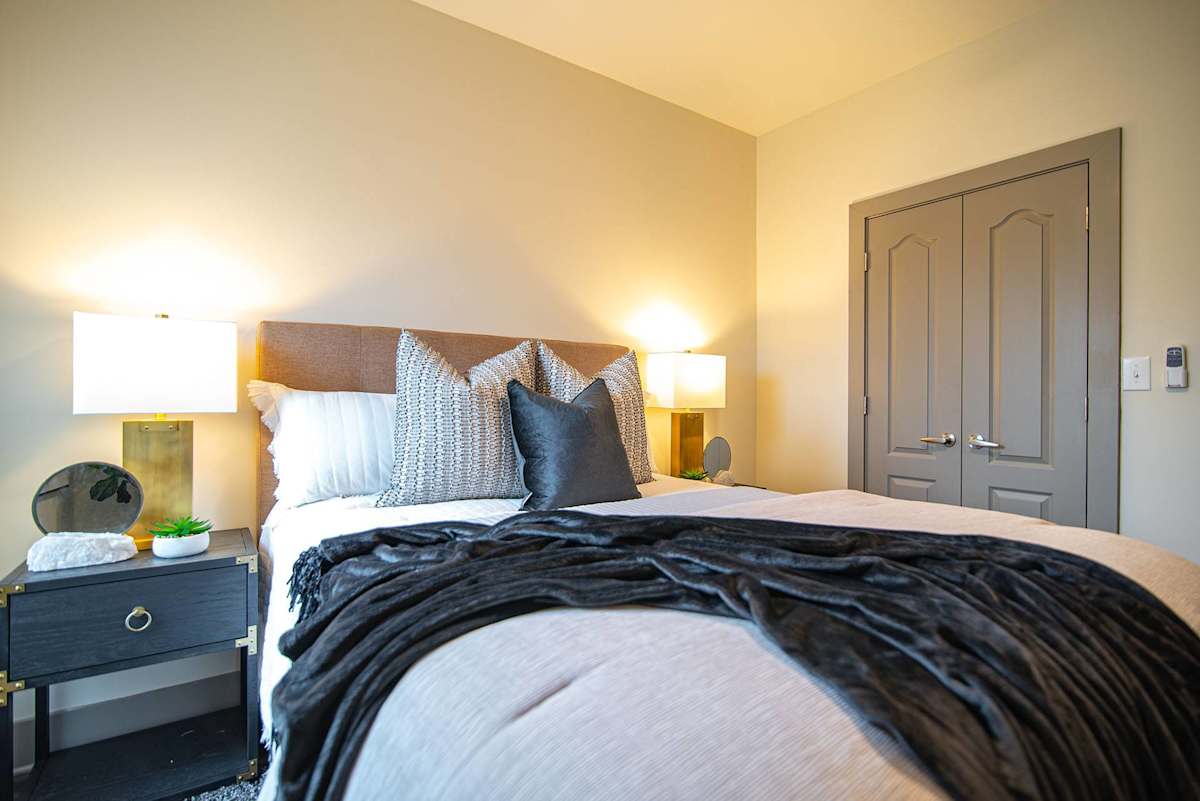 The Summit at Nashville West apartment bedroom with wall lamps - Nashville, TN