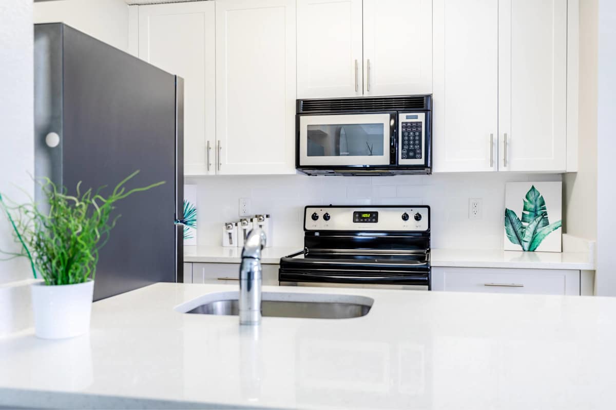 Palm Court at Wellington Apartments kitchen with black appliances - Wellington, FL