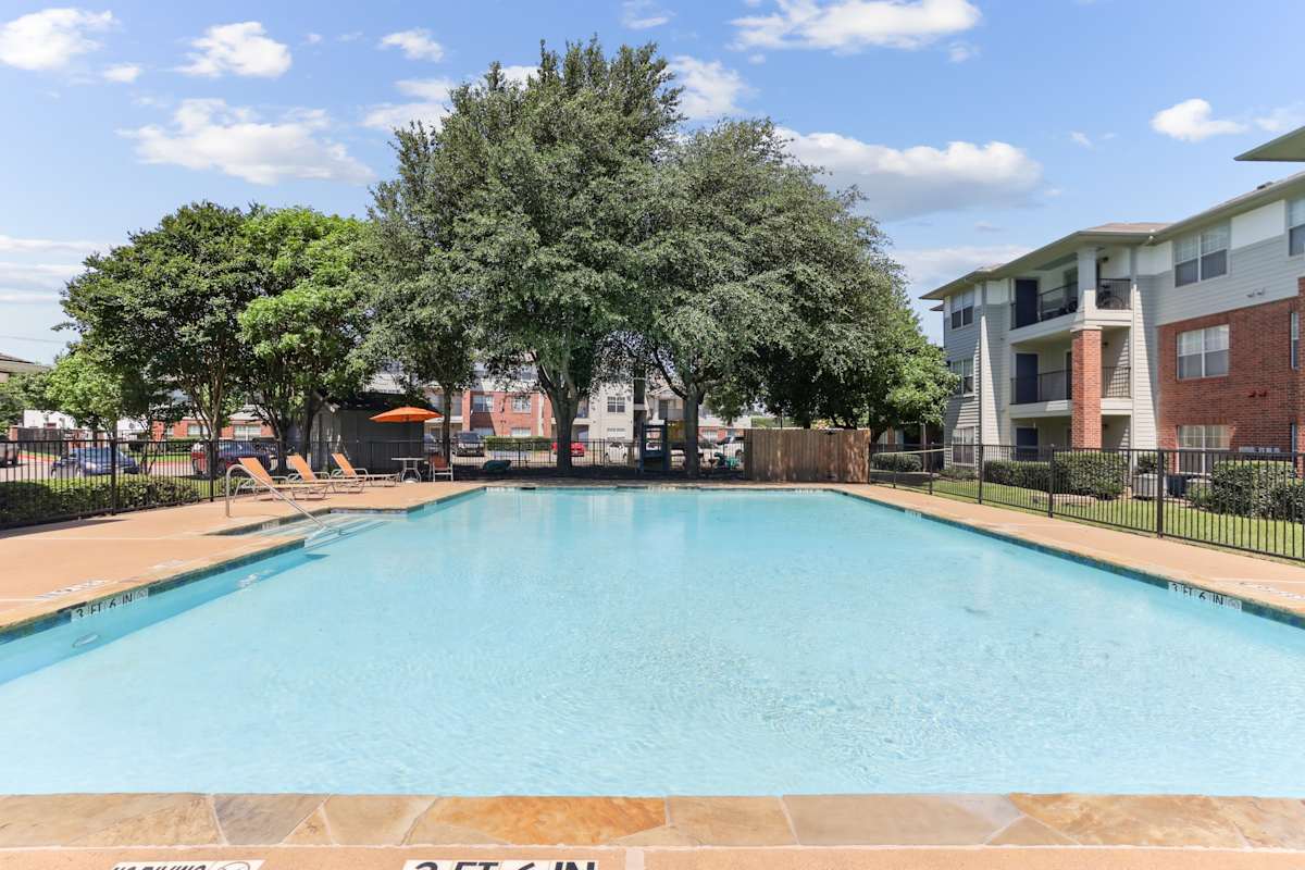 Flats at Five Mile Creek pool area with trees - Dallas, TX