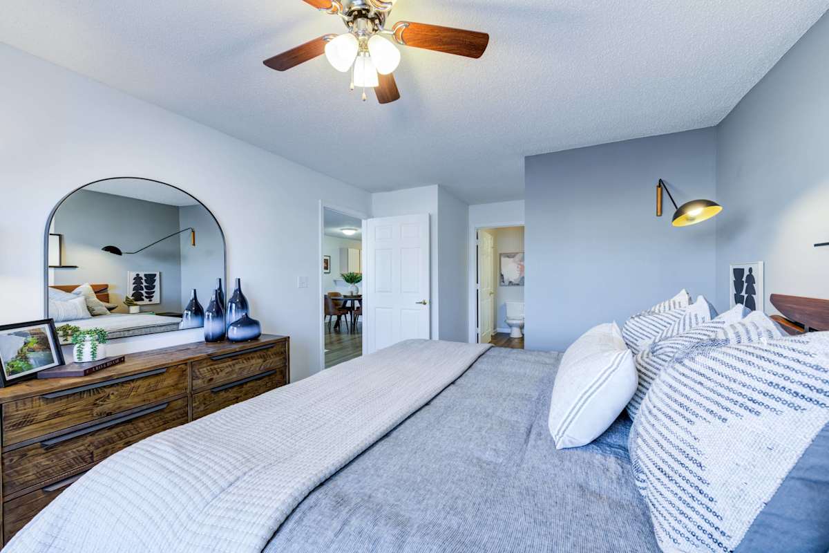 Legacy at Cross Creek bedroom with bed and ceiling fan - Fayetteville, NC