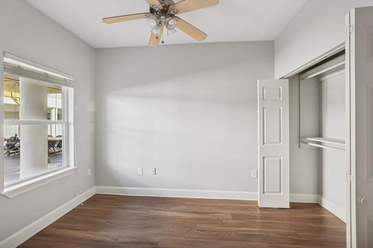 Wesley Place Apartments room with ceiling fan and door - Nashville, TN