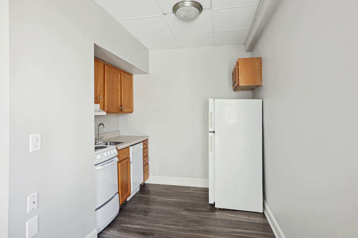 Barbizon Apartments kitchen with wood cabinets and white appliances - Nashville, TN