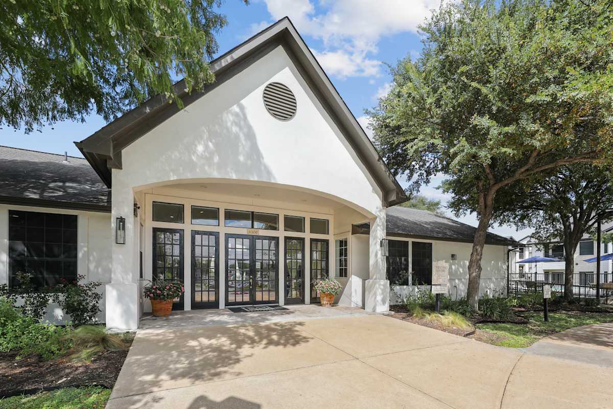 SoCo Apartments exterior entry with glass doors and trees - Austin, TX