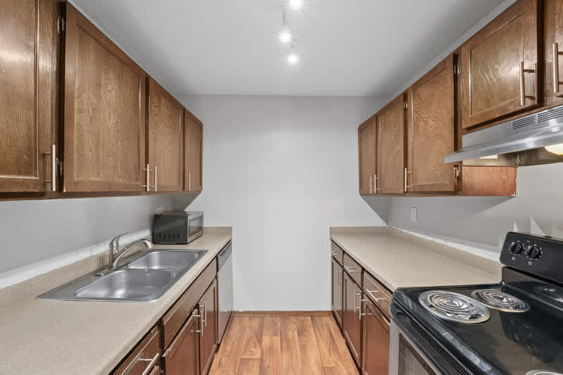 Grand Pre East kitchen with wood cabinets and black range - Little Canada, MN