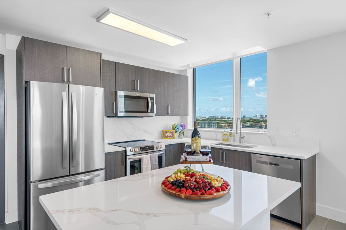 Vu New River apartment kitchen with stainless appliances and island - Fort Lauderdale, FL