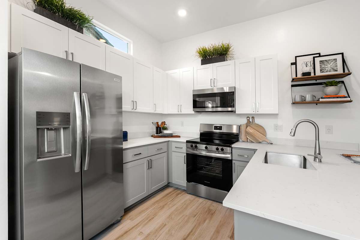 Stainless-steel appliances and white kitchen cabinetry at Avilla Vista Norte.