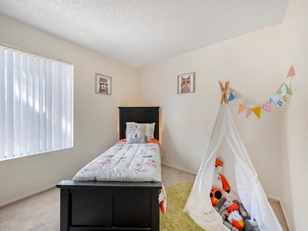 Furnished bedroom with window and closet storage — view 2 at Glen Oaks Apartments.