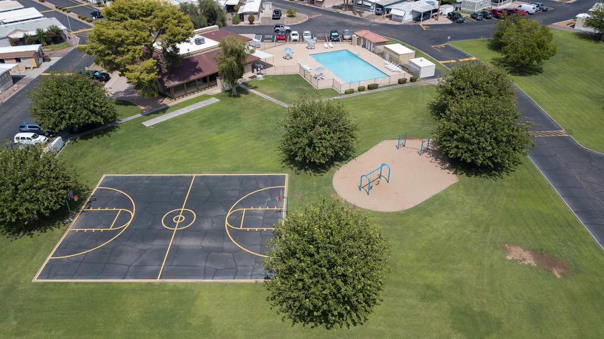 Basketball court beside the shared lawn and playground — view 1 at Belaire Manor MHC.