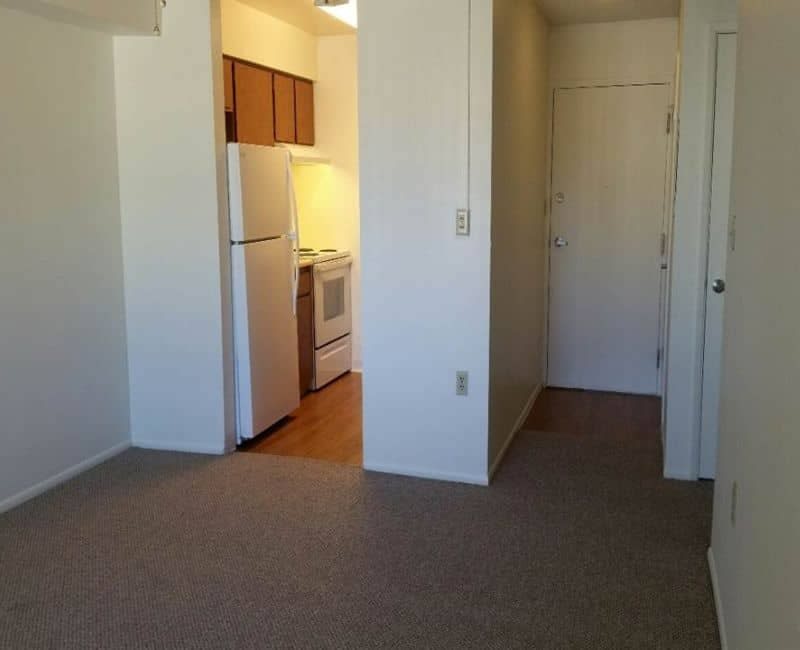 Unfurnished room with closet doors and adjoining kitchenette — view 2 at Kachina Place.