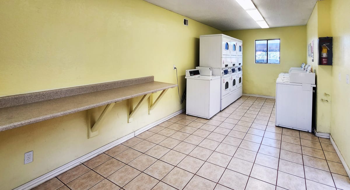Shared laundry room with folding counter — view 1 at Spinnaker Landing Apartments.
