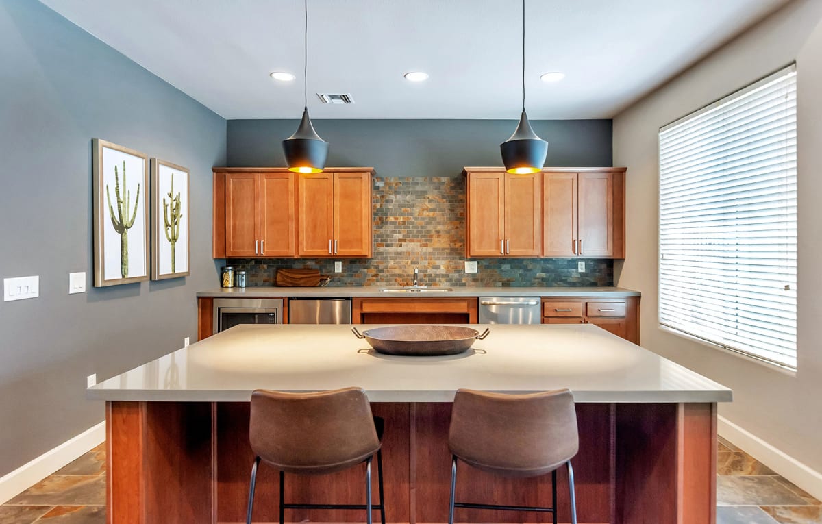 Community kitchen with island seating and pendant lights.