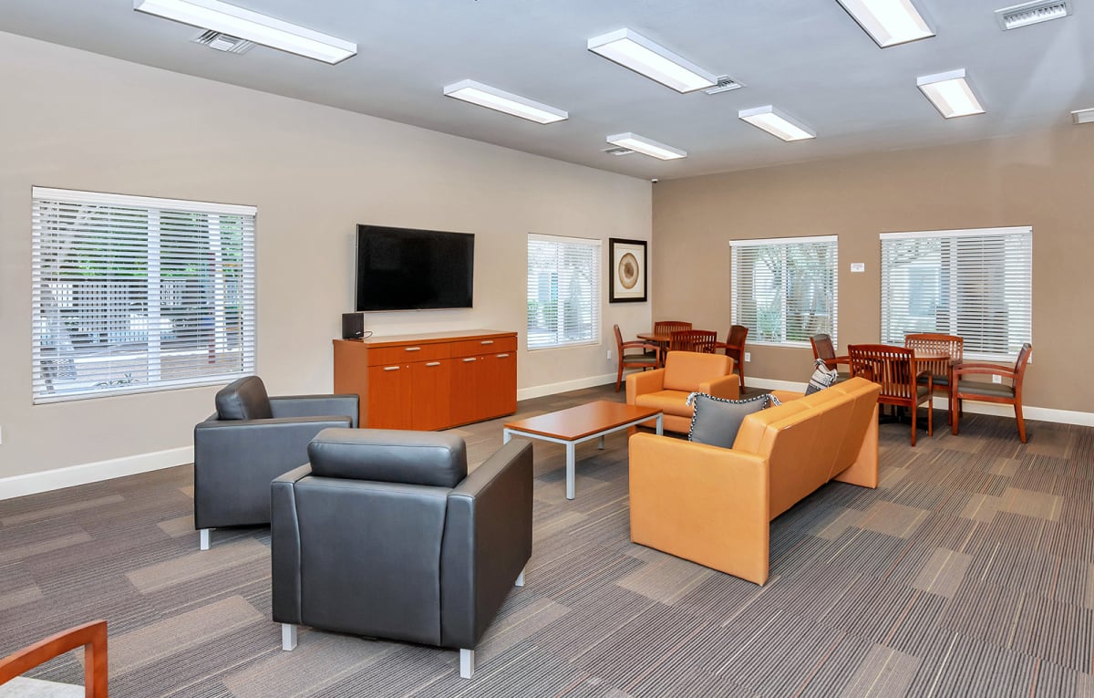 Community room with television and lounge chairs.