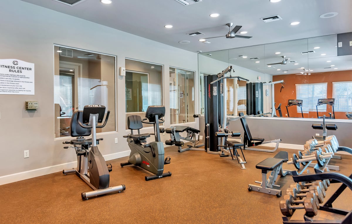 Fitness center with exercise bikes, weights and mirrors.