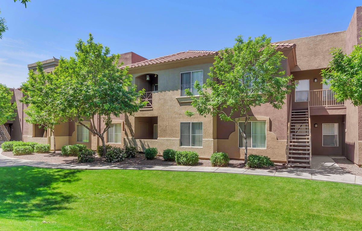 Two-story apartment building beside the lawn and walkway.