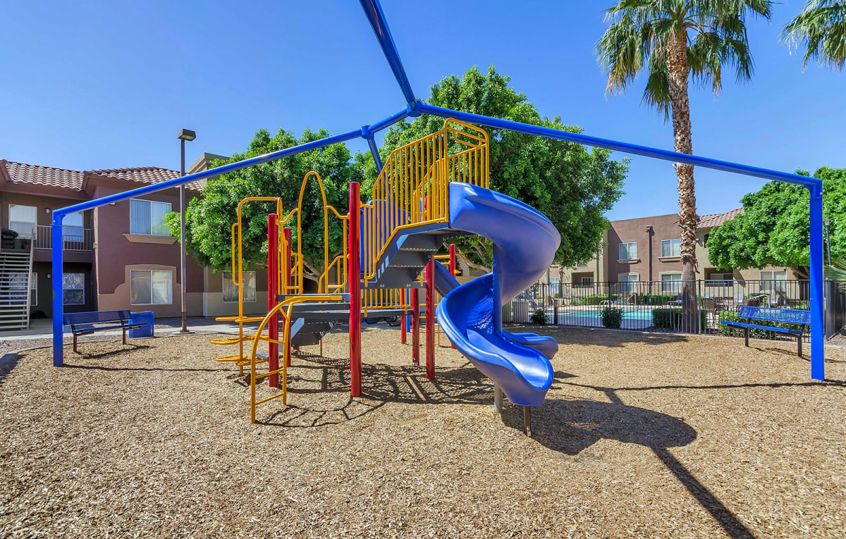 Outdoor playground with a blue spiral slide.