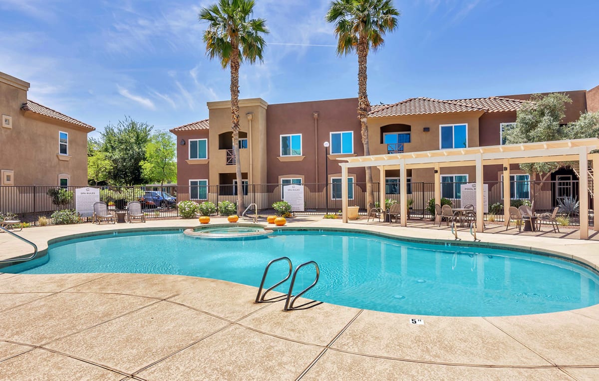 Outdoor pool with handrail and surrounding sun deck.