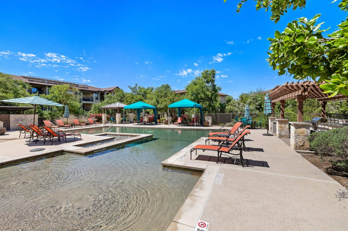 Lakeline East Apartments pool deck with umbrellas - Cedar Park, TX