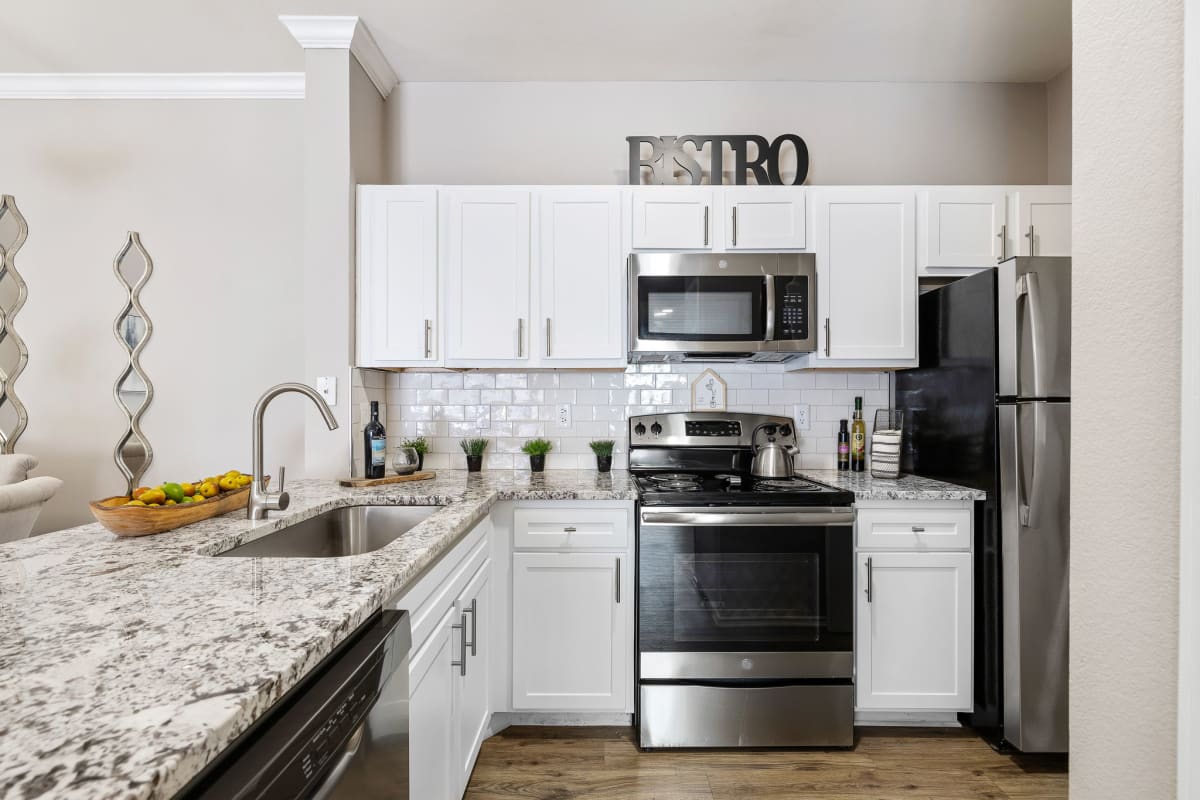 Sonterra Apartment Homes modern kitchen with white cabinets - Austin, TX