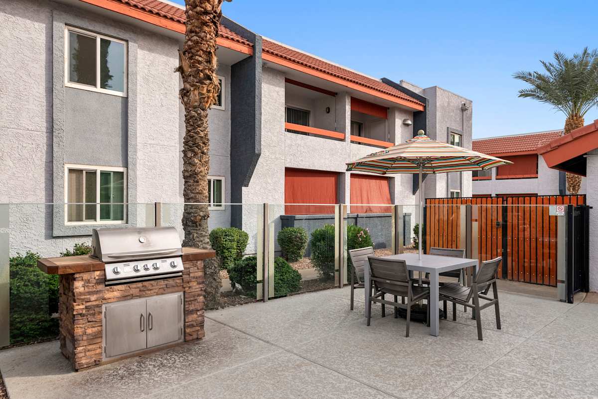 Outdoor grill and tables at West 35th Apartments.