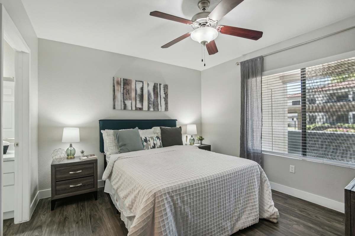 Furnished bedroom shown — representative home at Sonoran Apartment Homes.