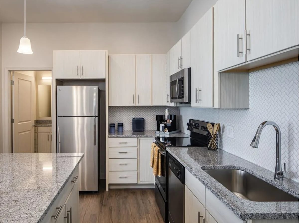 Kitchen with white cabinets and stainless steel appliances at 10X Tarpon Springs