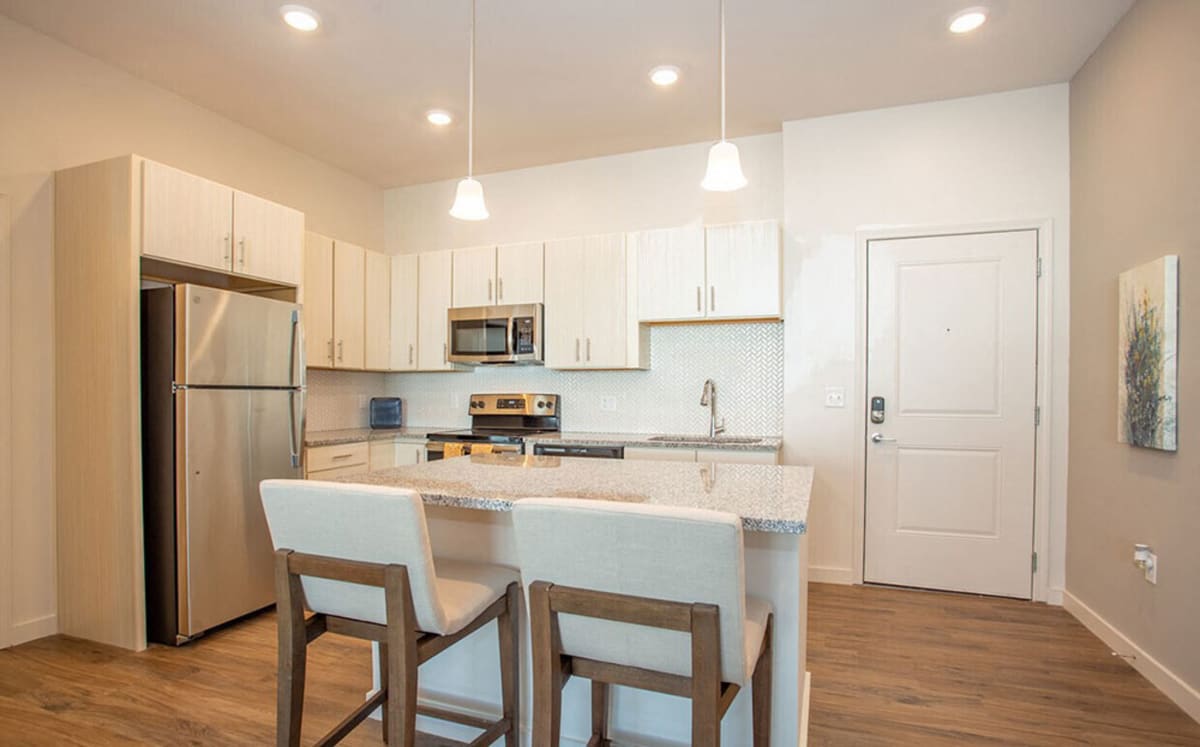 Kitchen with marble countertop and stainless steel refrigerator at 10X Tarpon Springs