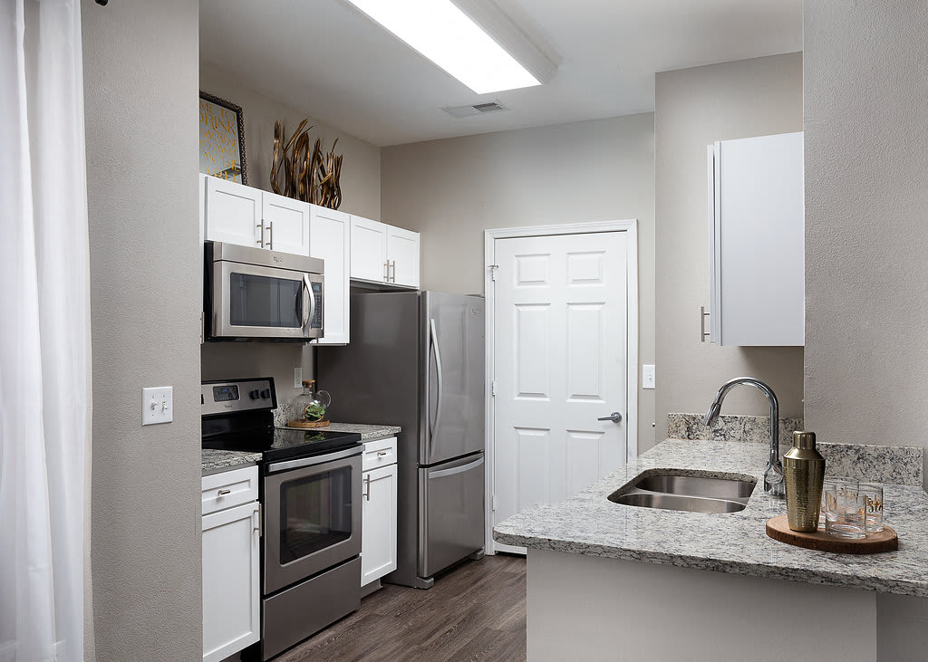 City Place at Westport apartment kitchen with granite countertops and stainless steel appliances - Kansas City, MO