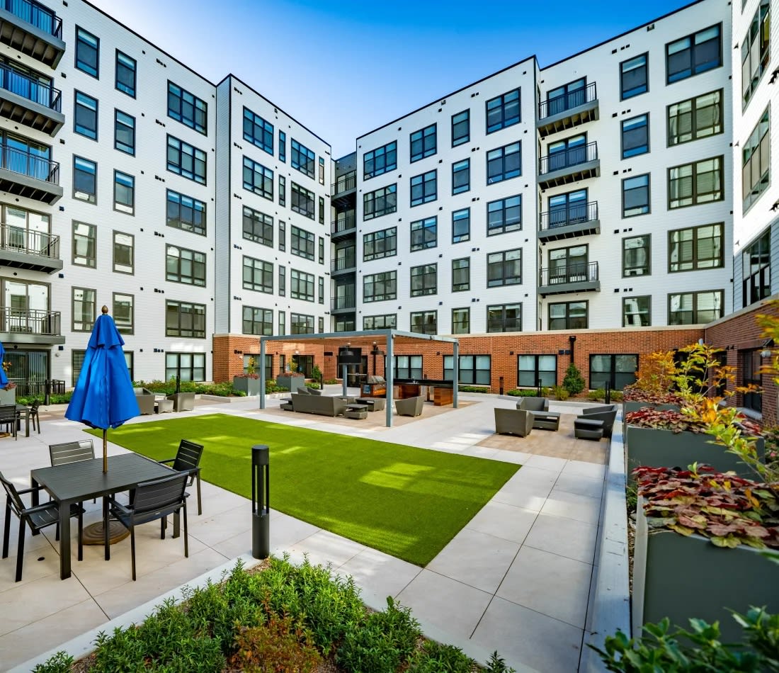 Harwood Flats landscaped courtyard with lawn and tables - North Bethesda, MD