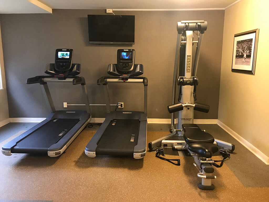 The 925 Apartments fitness room with treadmills and weight machine - Washington, DC