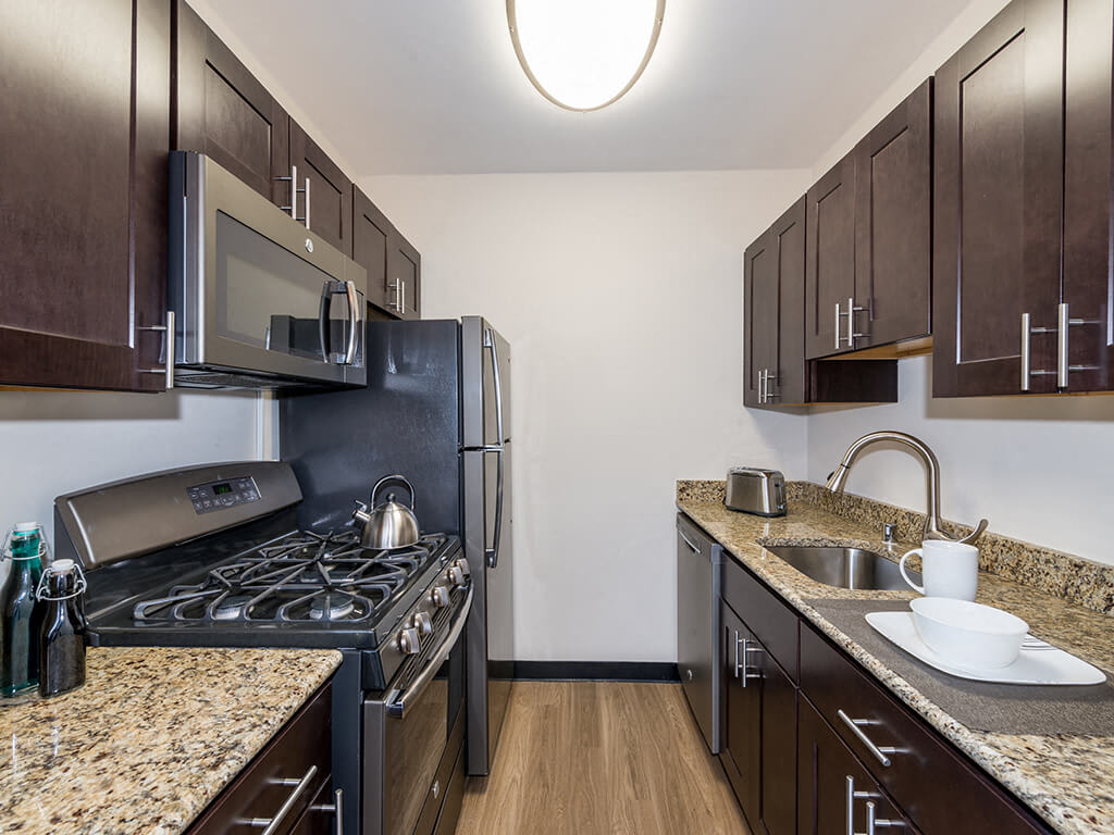 The 925 Apartments renovated kitchen with granite countertops - Washington, DC