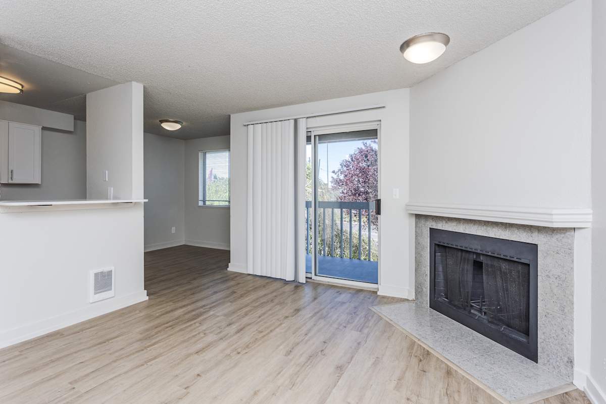 Ellyson Apartment Homes living room with fireplace and sliding door - Tacoma, WA