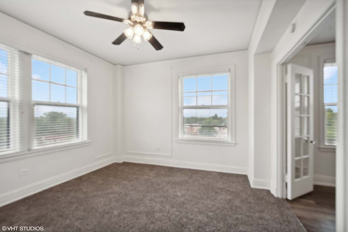 CWE Apartments living room with carpet and ceiling fan - St. Louis, MO