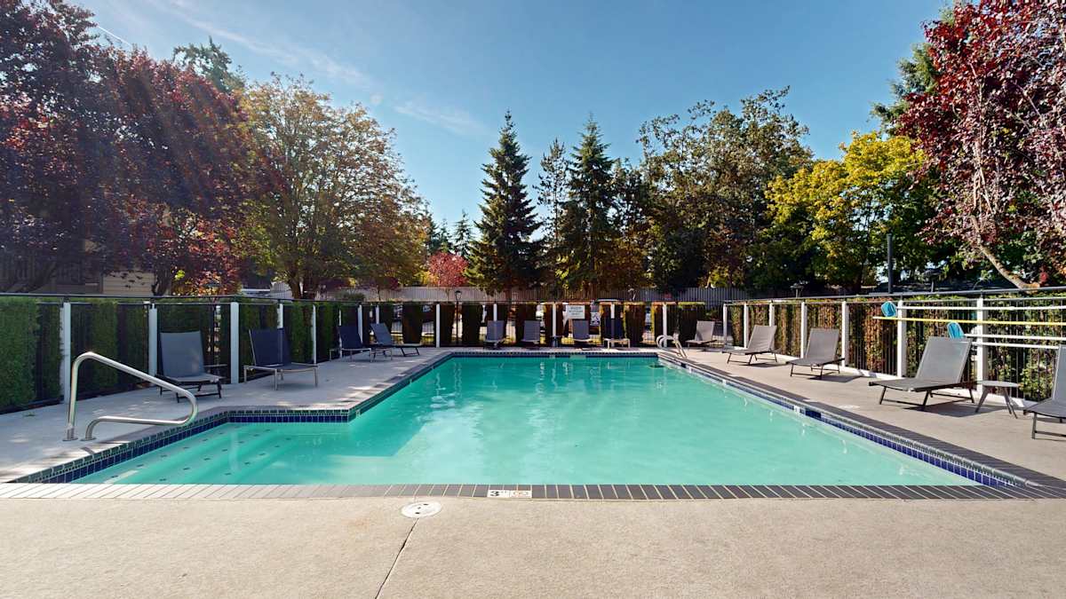 Ellyson Apartment Homes outdoor pool surrounded by trees - Tacoma, WA