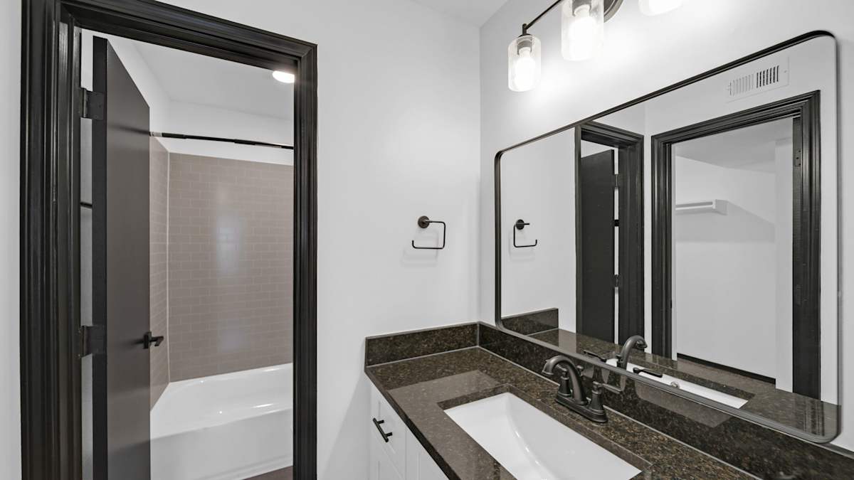 The District Apartments bathroom with vanity and mirror - Memphis, TN