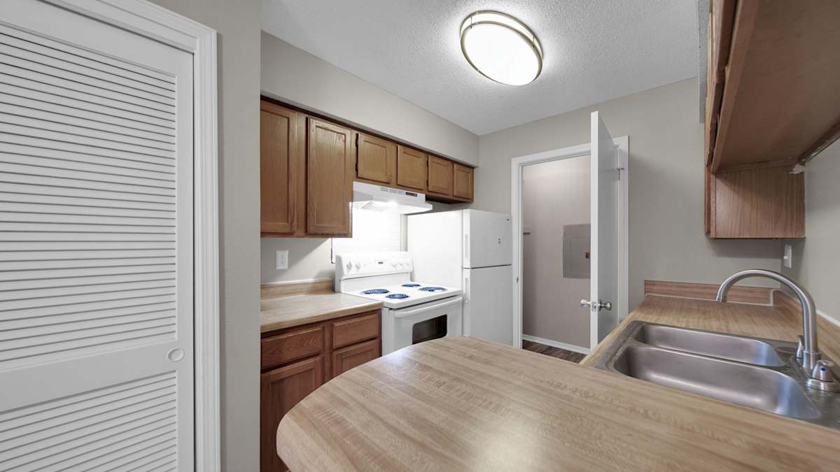 The Local Apartments kitchen with wood-look counters and white appliances - Memphis, TN