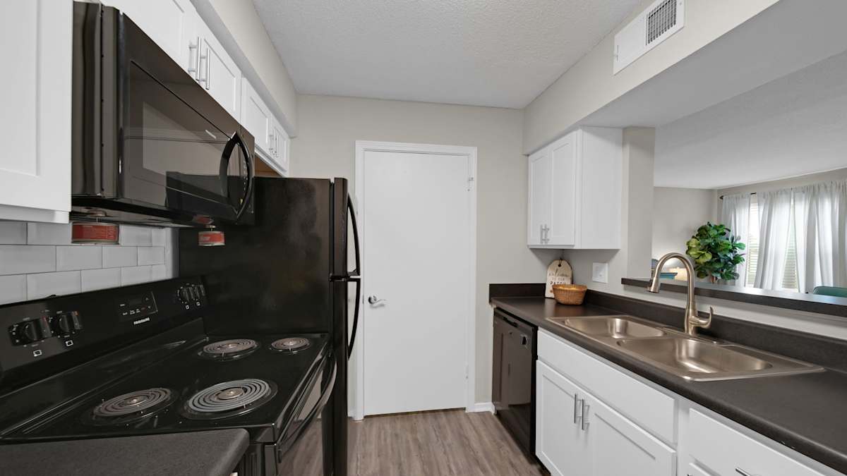 The Local Apartments kitchen with black range and microwave - Memphis, TN