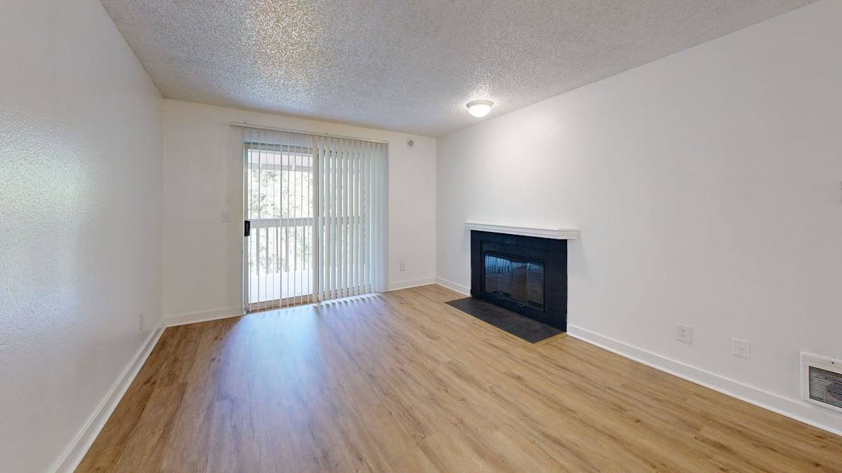 Ellyson Apartment Homes living room with fireplace and sliding door - Tacoma, WA